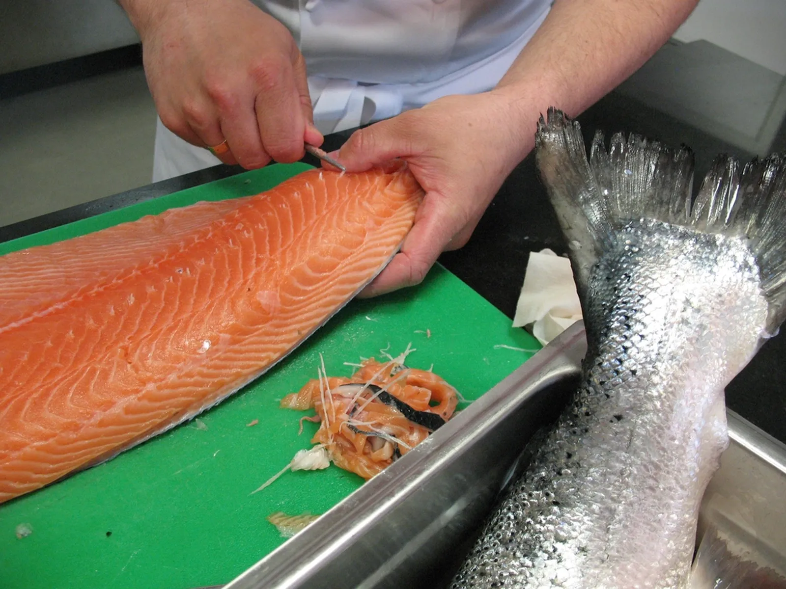 Le chef lève un filet de poisson entier